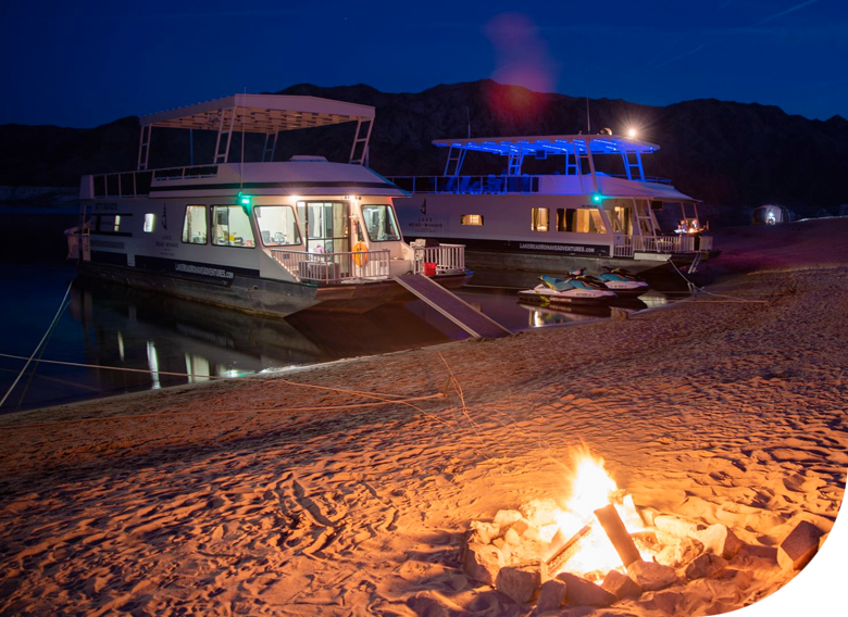 Houseboats docked in the evening with a fire pit on the beach